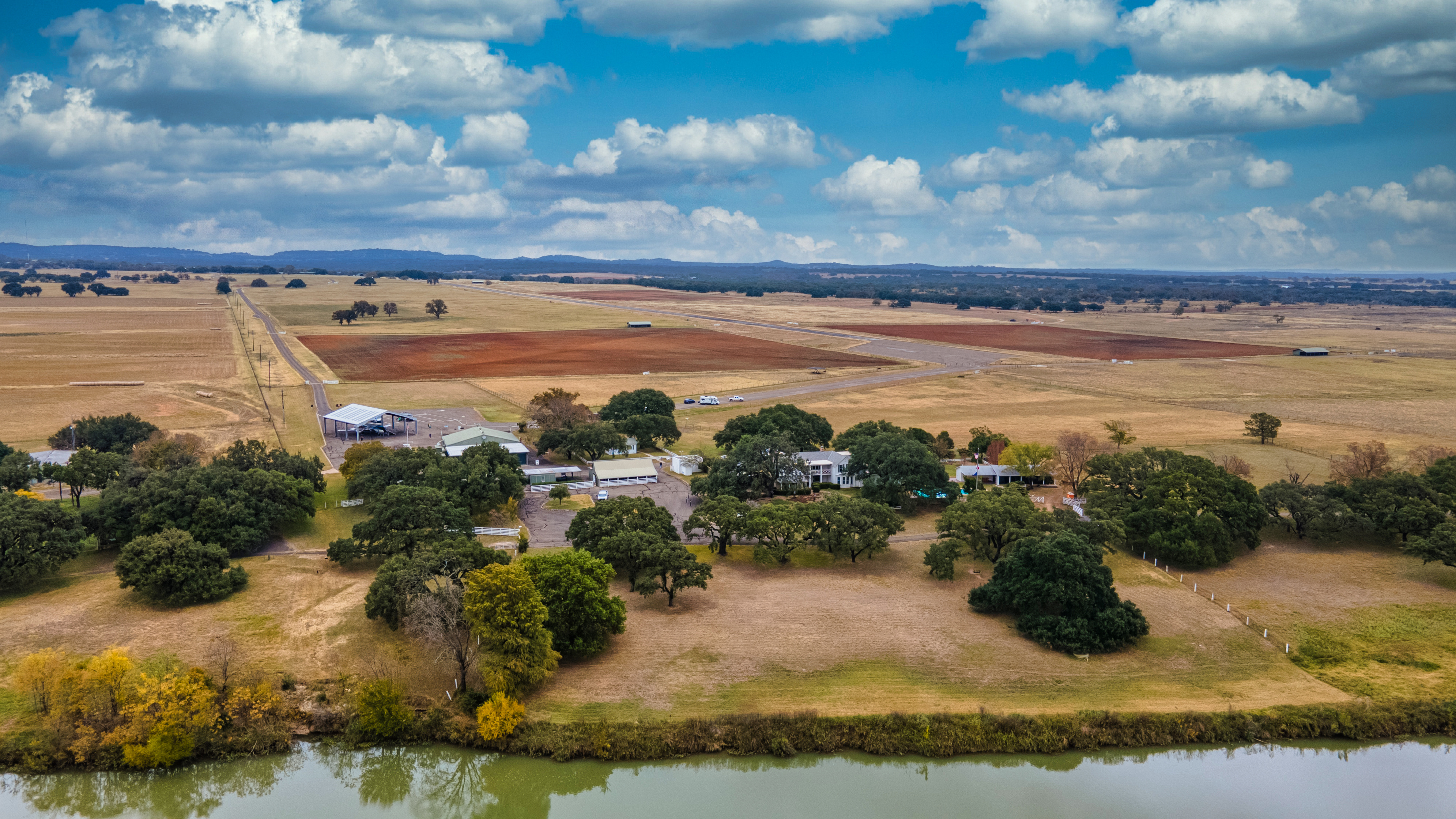 An aerial view of the Texas White House and airstrip under a bright blue sky.