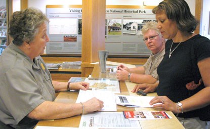 Park ranger assisting visitor at information desk Park ranger assisting visitor at information desk