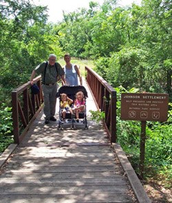 A family crosses the bridge to the Johnson Settlement