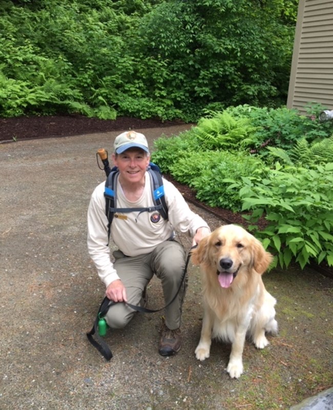 Volunteer poses with golden retriever