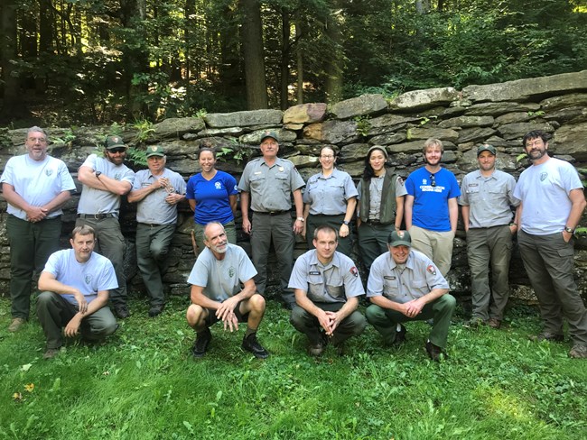 Group of 13 adults in park uniforms pose for a picture