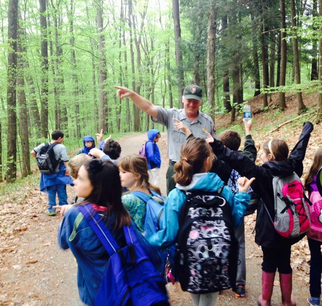 Students on trail with Kyle looking at trees Students on trail with Kyle looking at trees