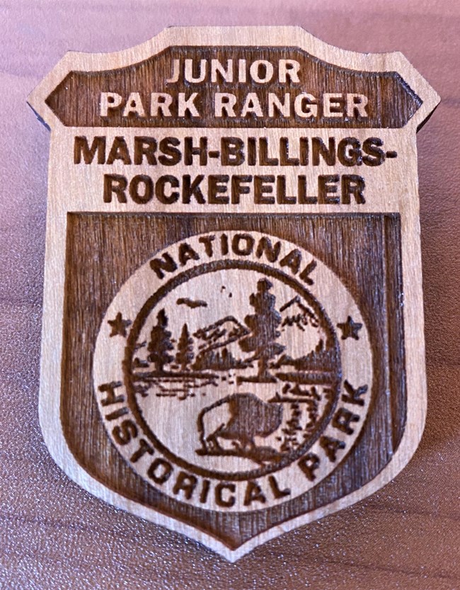 wooden badge with text Junior Park Ranger Marsh-Billings-Rockefeller National Historical Park
