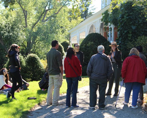 Park Ranger talks to visitors in front of historic mansion