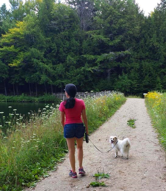 Walker with small white dog at the Pogue (lake)