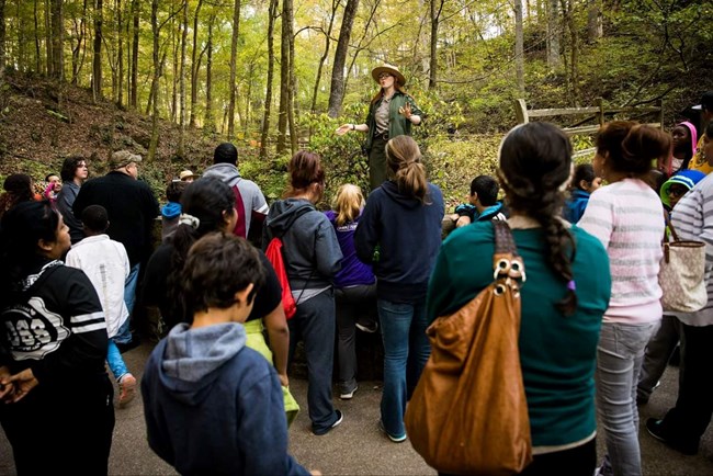 A park ranger gives a talk to park visitors near the cave entrance