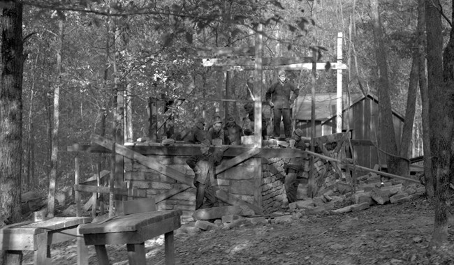 A black and white photo of a stone building under construction.