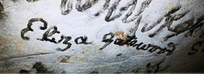 A name written on the cave ceiling with black smoke.