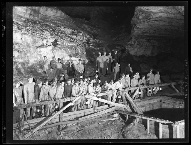 A group of men standing next to the saltpetre vats