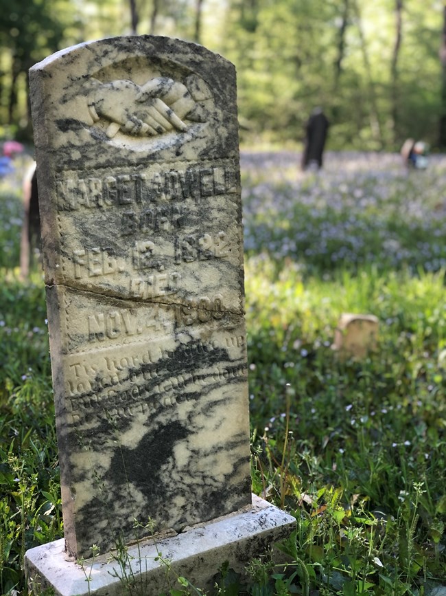 A marble headstone with a crack down the center.