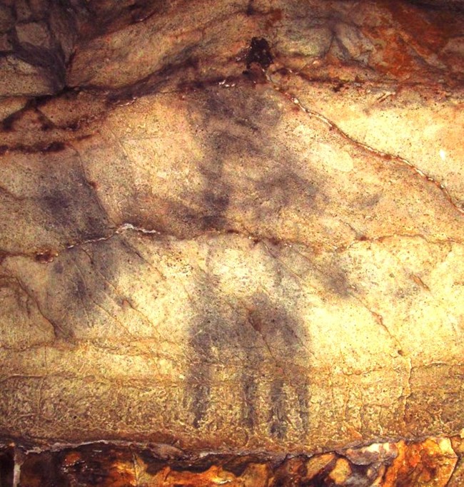 a charcoal drawing on a cave wall