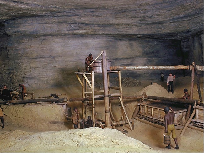 A diorama showing men working in the saltpetre operation