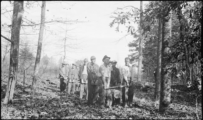 A group of men carrying a large wooden pole.