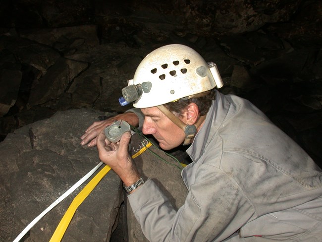 A cave researcher reading a compass