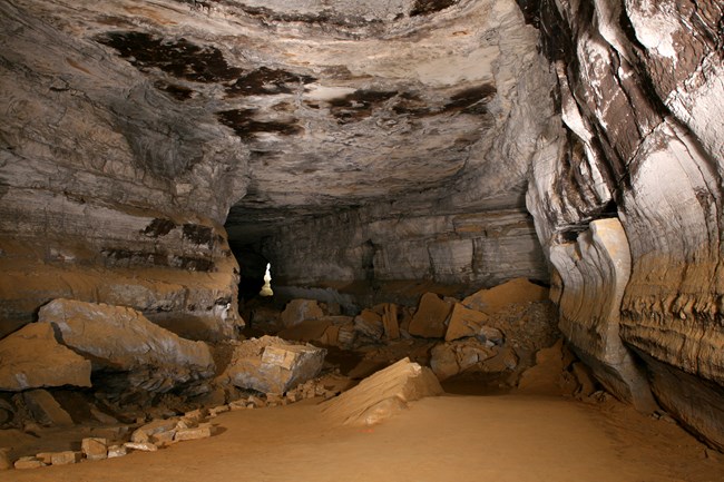 A dirt cave trail in a large cave passage.