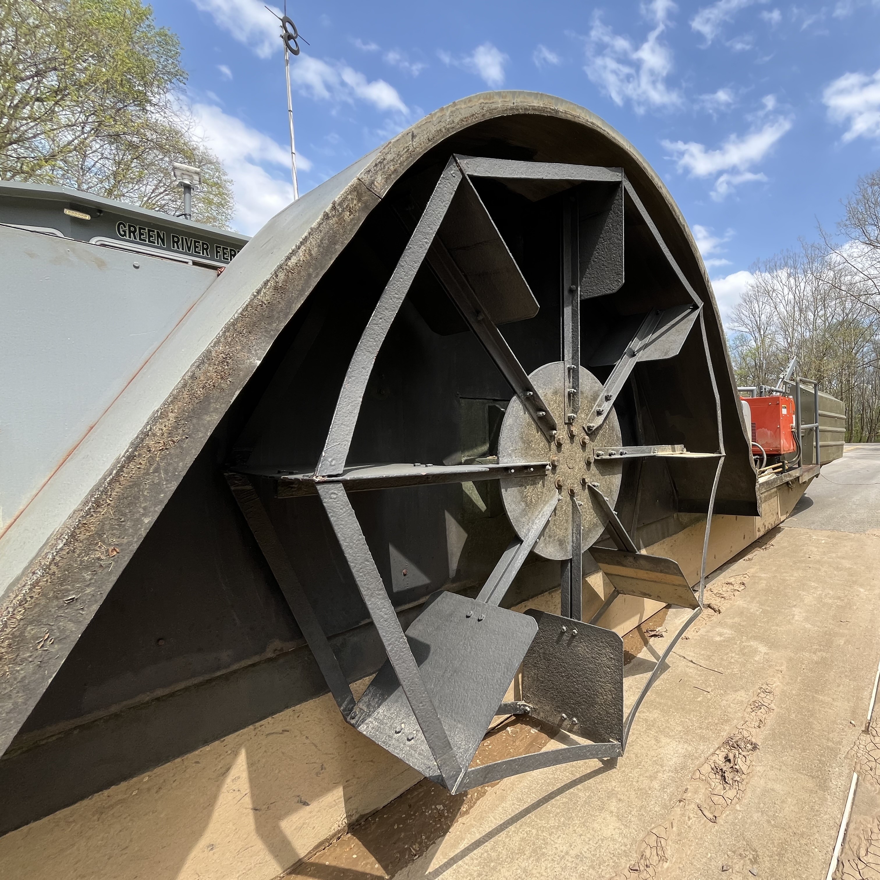 A closeup image of a large, silver metal paddlewheel used to navigate a ferry vessel.