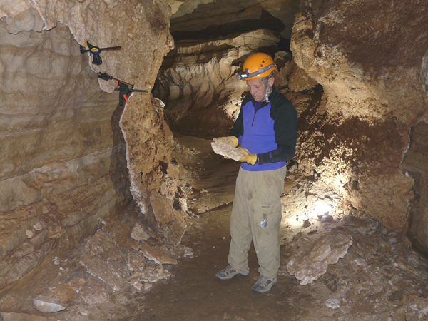 Jim Werker examines a glued and clamped section of gypsum that he is reattaching to a wall in Crystal Cave.
