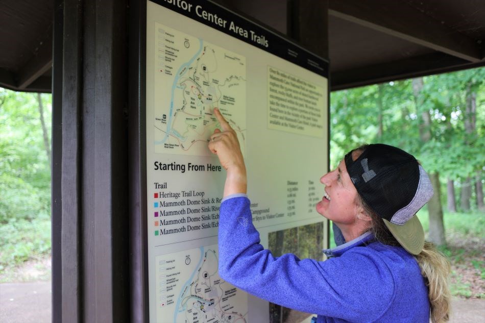A visitor points out her route using a large kiosk map.