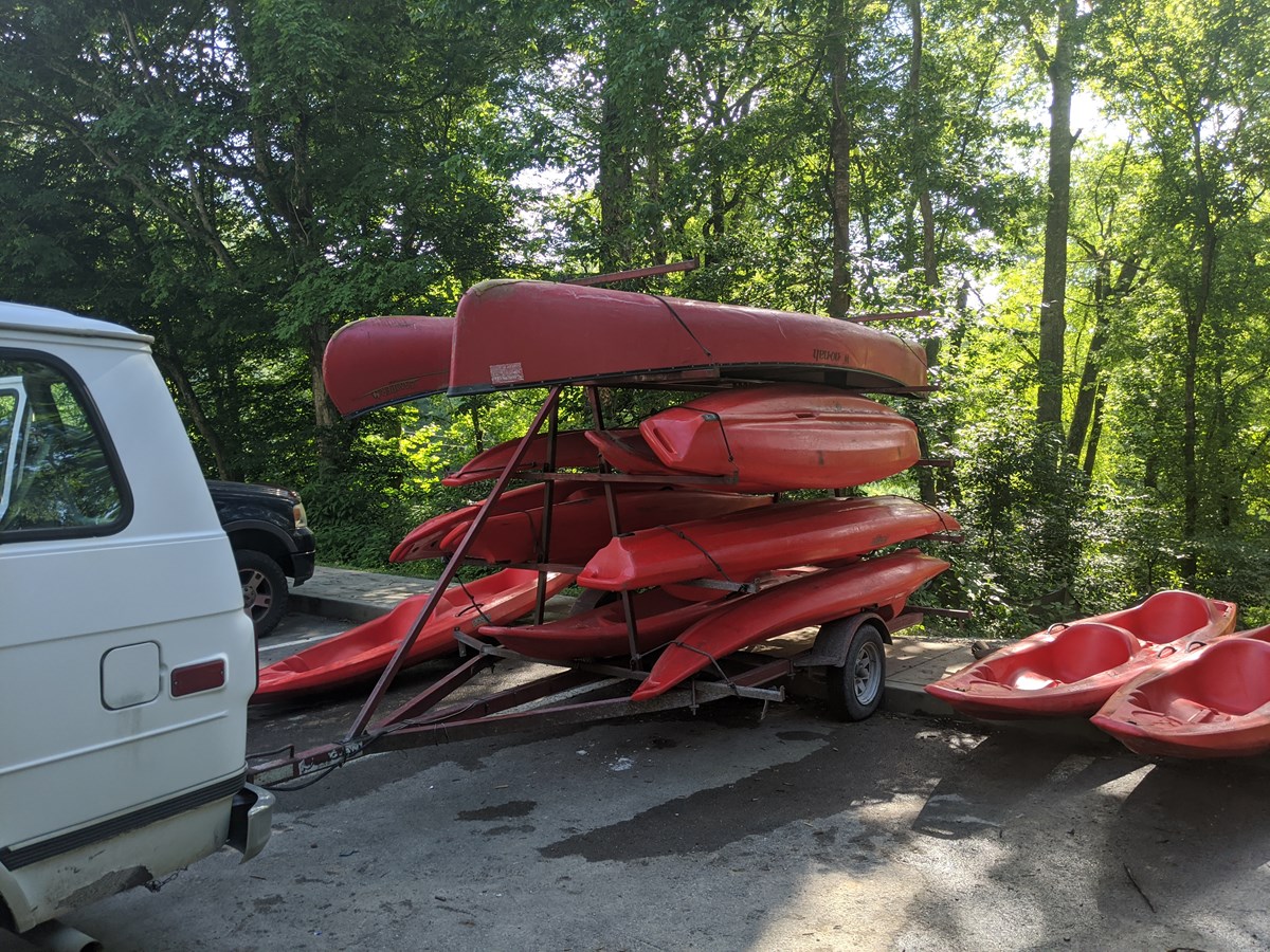 Kayaks stacked up on a trailer used by a canoe and kayak outfitter.