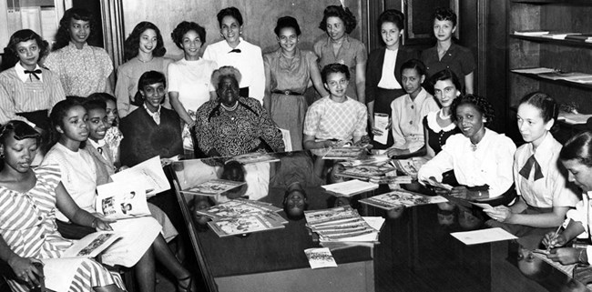 Women sitting and standing around a large table