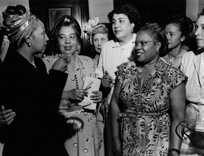 Josephine Baker speaks with Vivian Carter Mason and other NCNW members at a reception in the Boardroom at the Council House