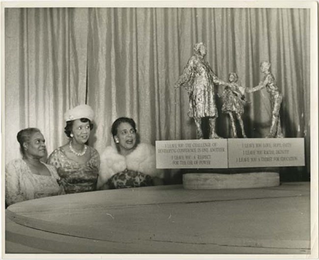 Three women view model of Bethune Memorial