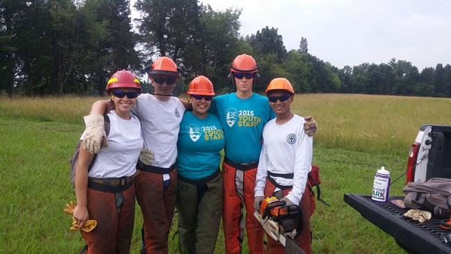 YCC crew posing for a picture in personal protective equipment and holding tools