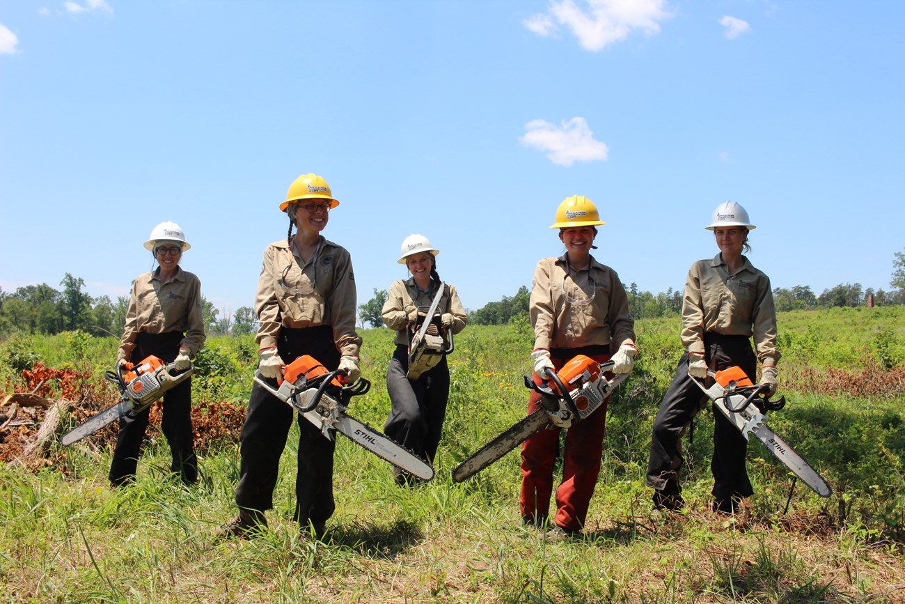 Appalachian Conservation Corps members pose with chainsaws at Deep Cut.
