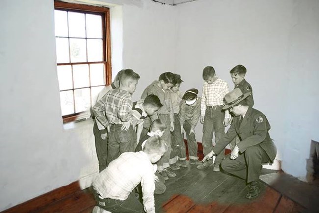 A now and then photograph of a school field trip in the Stone House circa 1960.