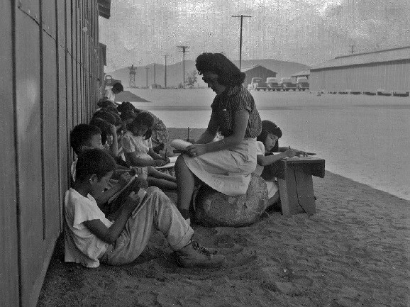 Teacher helps students with writing outside of building