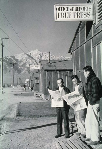 Group reading newspaper in front of office Group reading newspaper in front of office