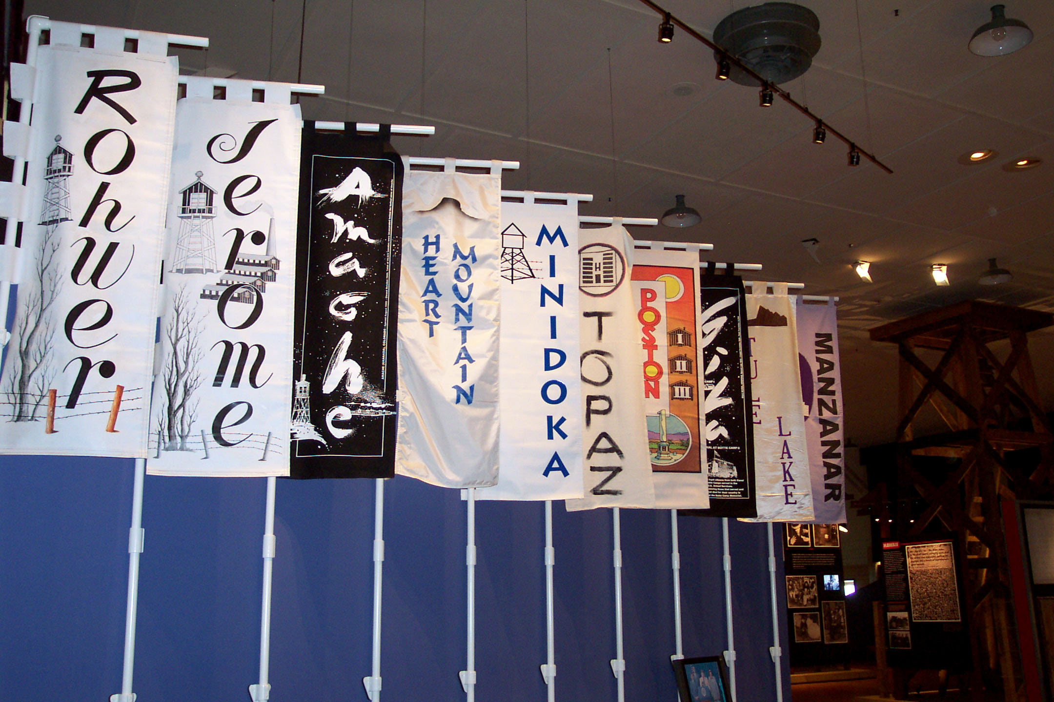 Manzanar Visitor Center banners vertical banners with painted names and designs hang in large room
