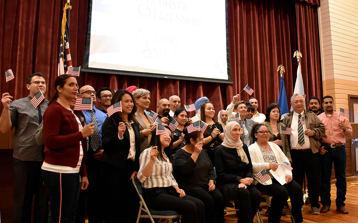 Group of adults with small US flags in their hands