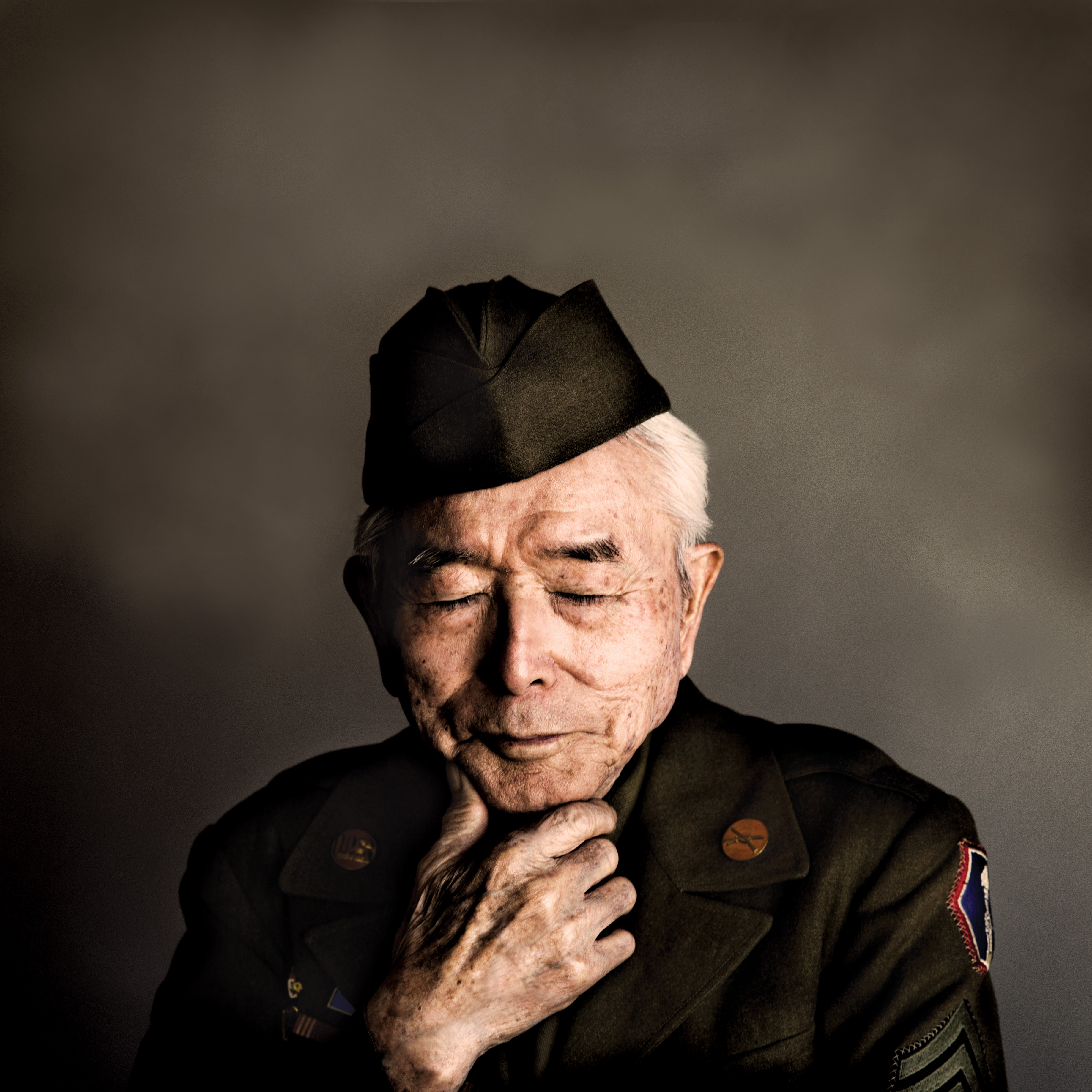 photo of a Japanese American man in US Army uniform looking downward