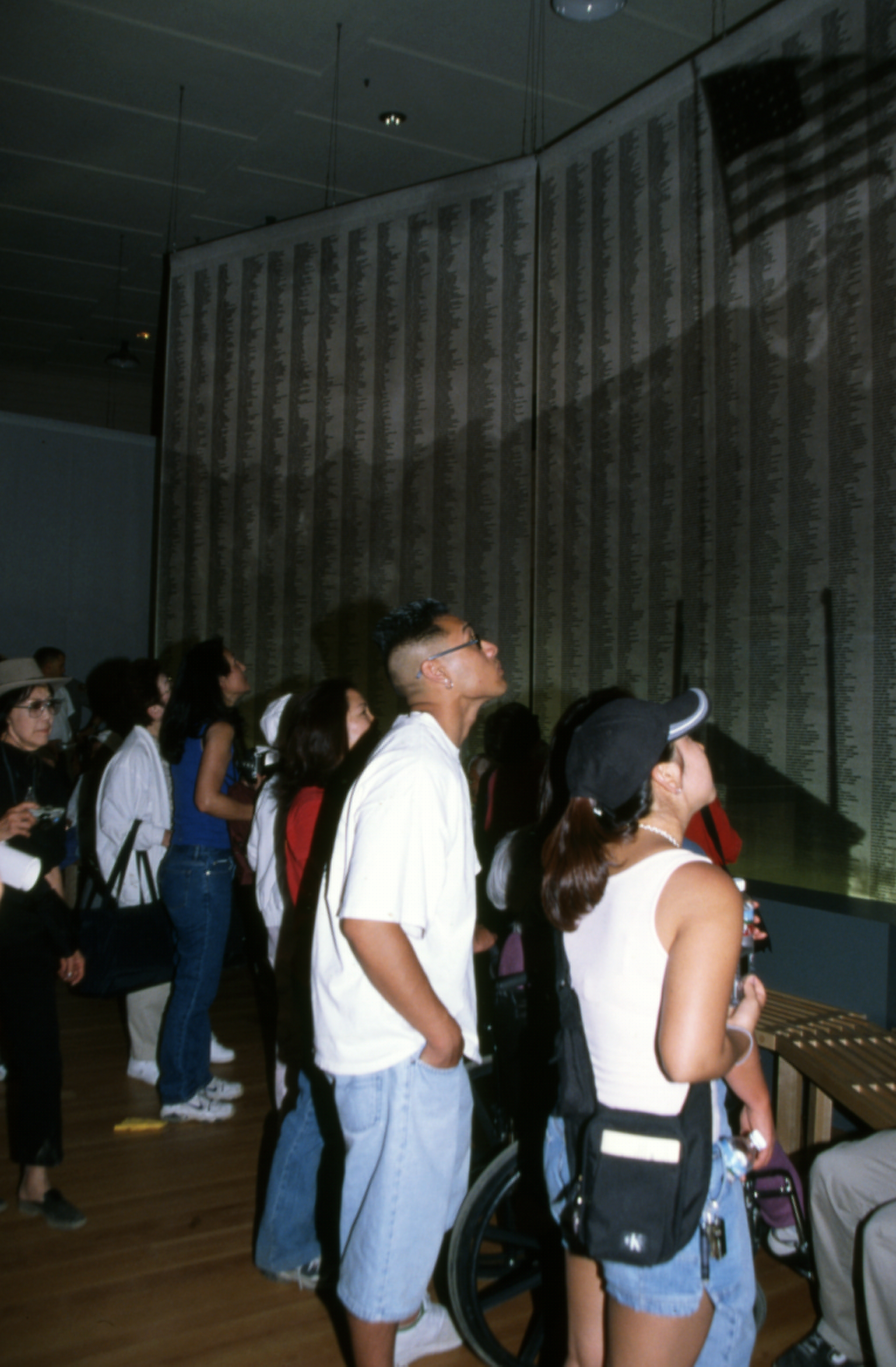 Visitors looking at wall of names (IFECC-118) people look upwards towards list of names