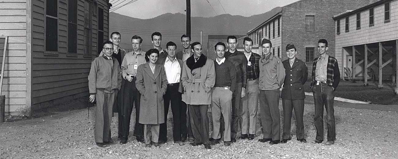 Black and white photo of a group of people in between some buildings.