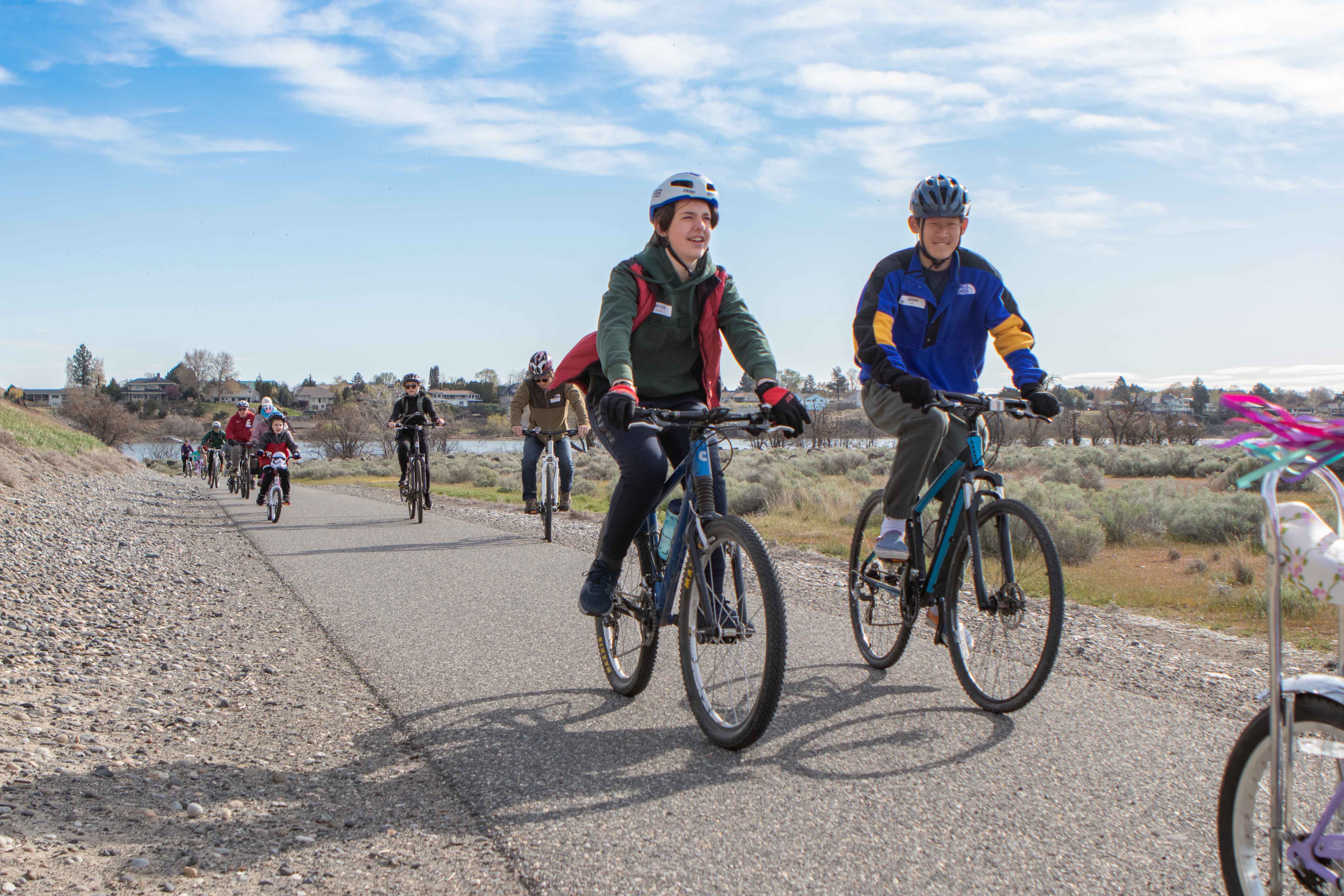 Two men riding bikes with helmets on.