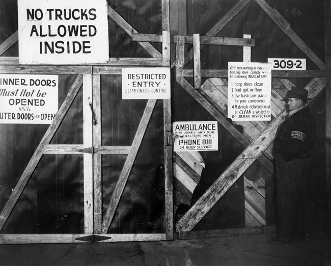 Signs with security notices adorn the entrance to a building at K-25.