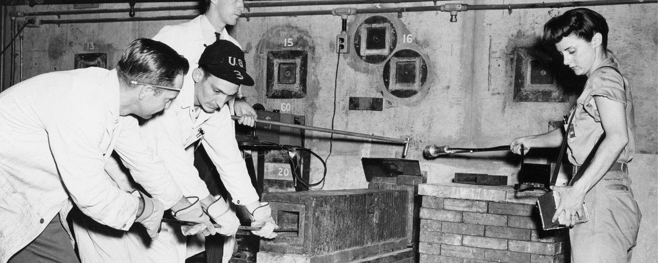 Three men and one woman extract scientific samples from the reactor.