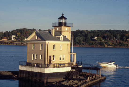 Rondout Creek Lighthouse with a passing boat in New York's Hudson River
