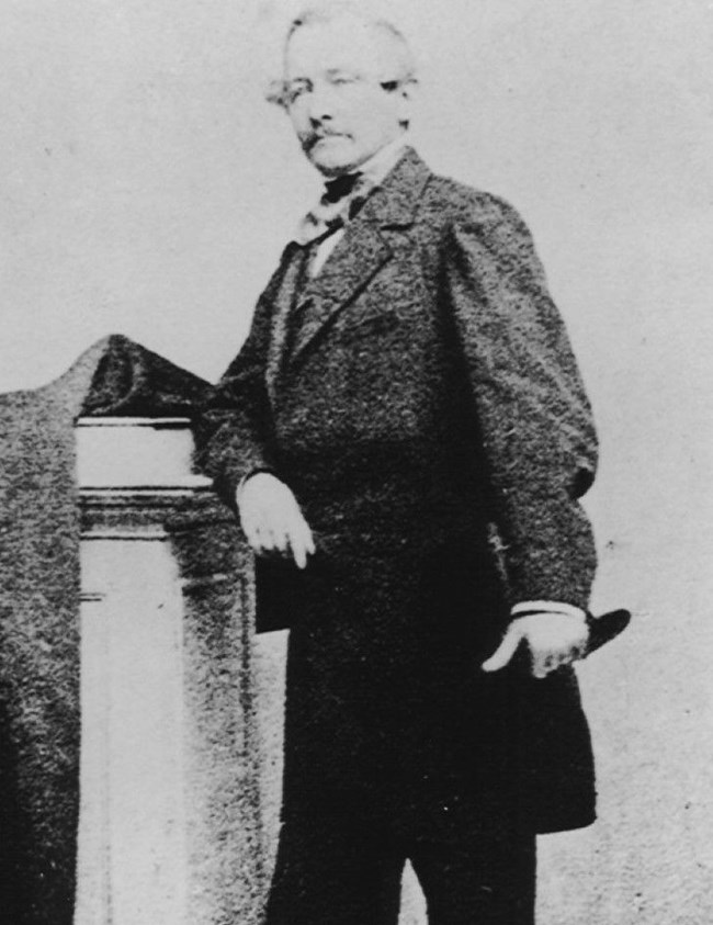 Abraham Van Buren Posing next to a pillar in dress clothes