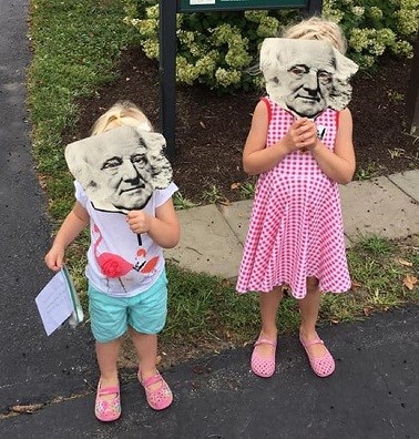 Children hold up masks of Martin Van Buren's face