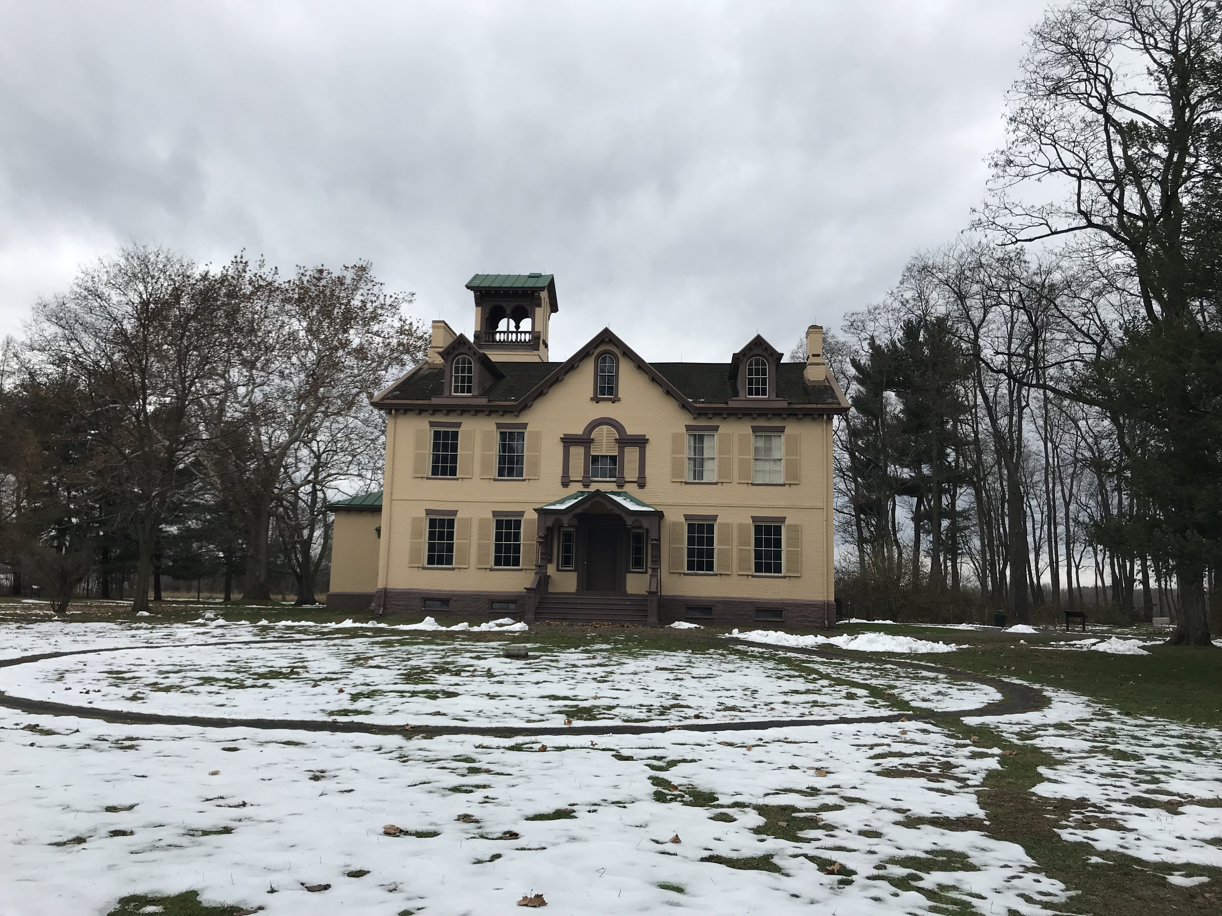 Lindenwald in Winter Large yellow house with snow and slate gray sky in background