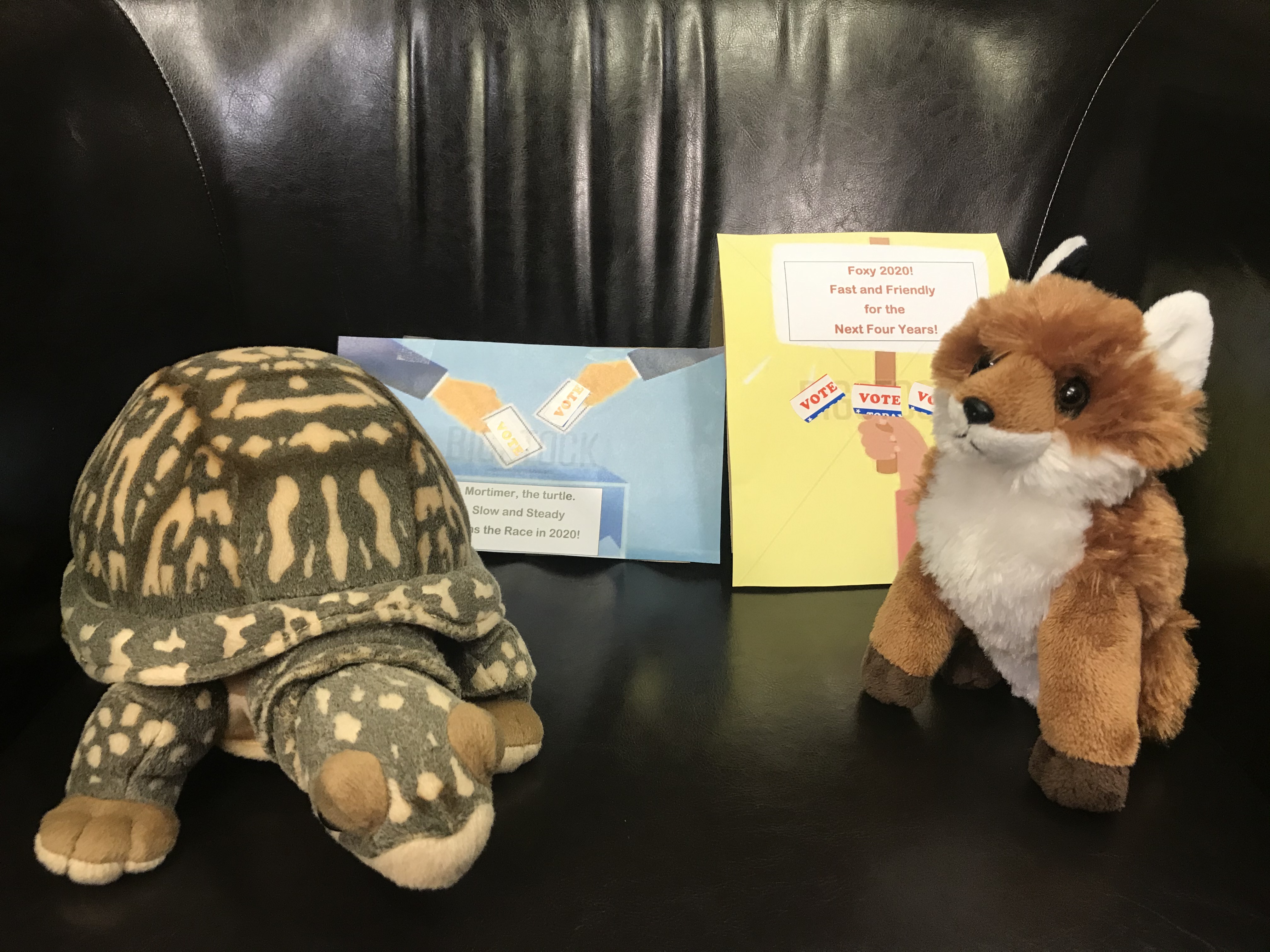 Candidates for Lindenwald Election A stuffed turtle and a stuffed fox sitting on a chair with campaign slogans
