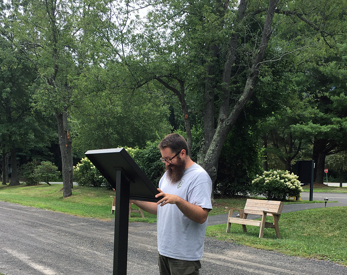 Ranger reads the phenology trail information at Martin Van Buren National Historic Site.
