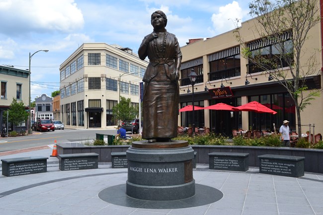 bronze statue of a woman in the middle of an open plaza