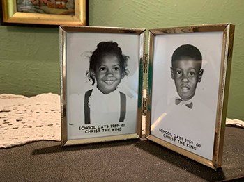 Bifold frame with black and white photos of young girl on left and young boy on right