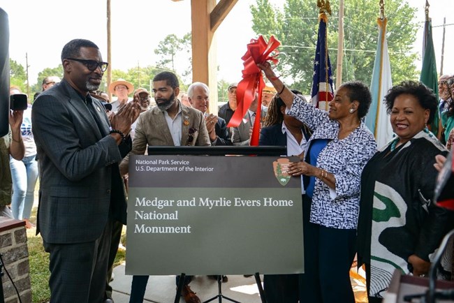 Myrlie Evers, and daughter Reena Evers-Everette unveil the park sign at a ribbon cutting event