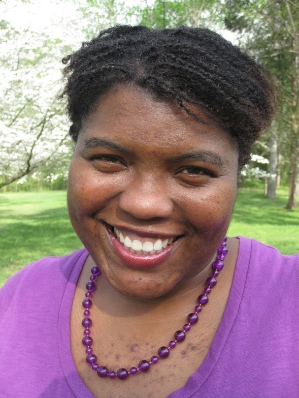 Superintendent Keena Graham smiling wearing a purple shirt and necklace.