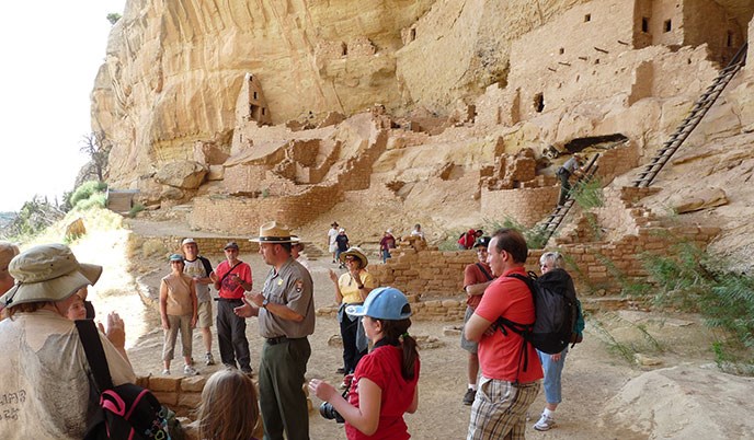 Interpretive ranger with visitors at the Long House cliff dwelling.
